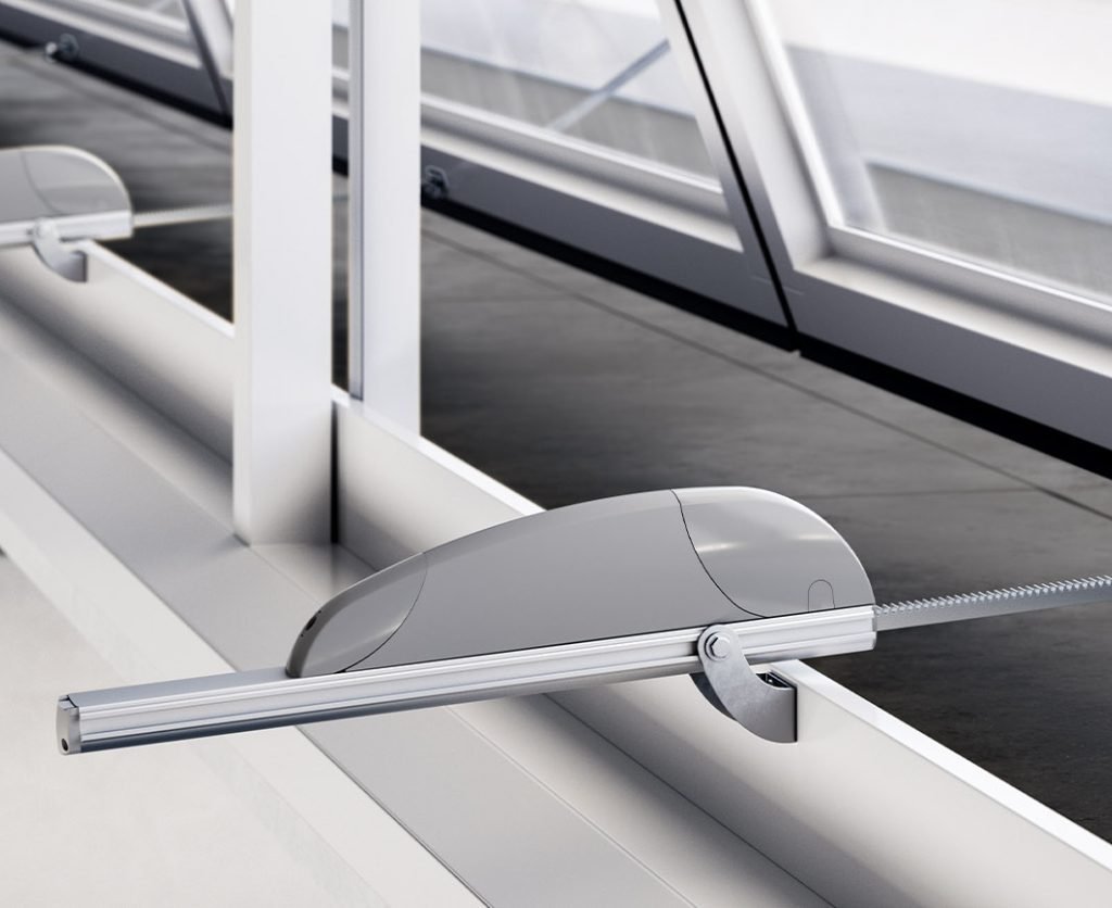 Interior view of a Comunello Mowin automated actuator installed on a long row of industrial shed windows.